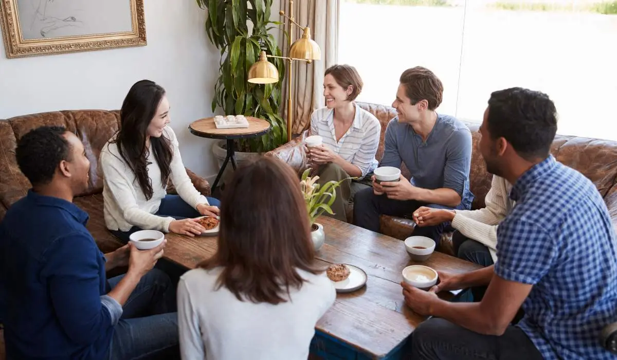 a large group of friends talking over a cup of coffee