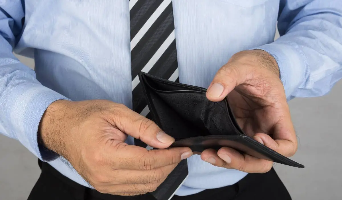 a person in a blue shirt and tie is holding an empty wallet